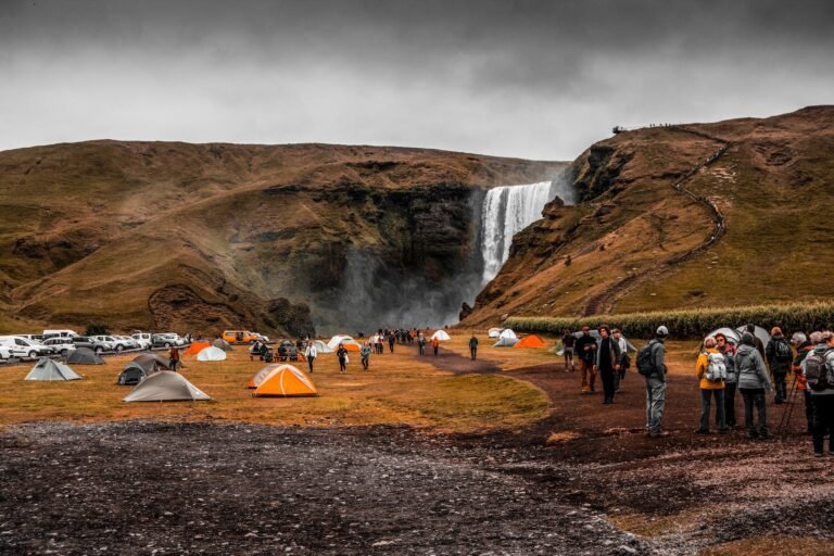 people standing on camping site near waterfalls